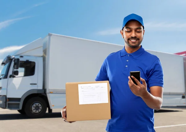 Indian delivery man with smartphone and parcel box — Stock Photo, Image