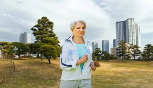 Mujer mayor corriendo a lo largo del parque de verano —  Fotos de Stock