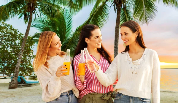 Mulheres jovens brindando bebidas não alcoólicas na praia — Fotografia de Stock