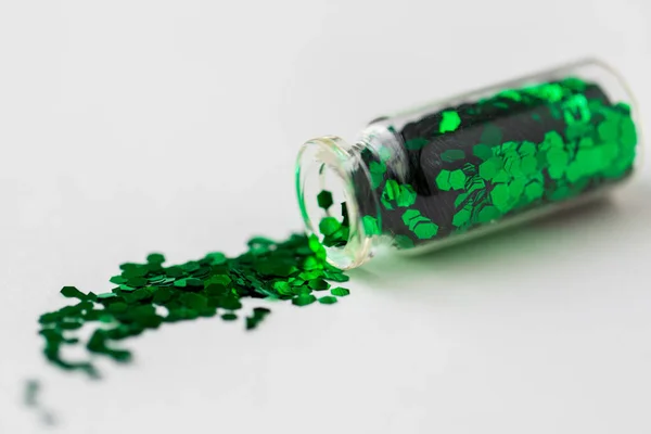 Grönt glitter hälls från små glasflaska — Stockfoto