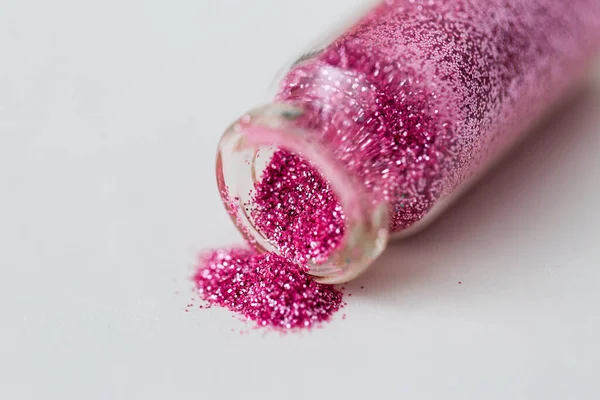 Рожеві блискітки, наливаються з маленької скляної пляшки Стокове Фото