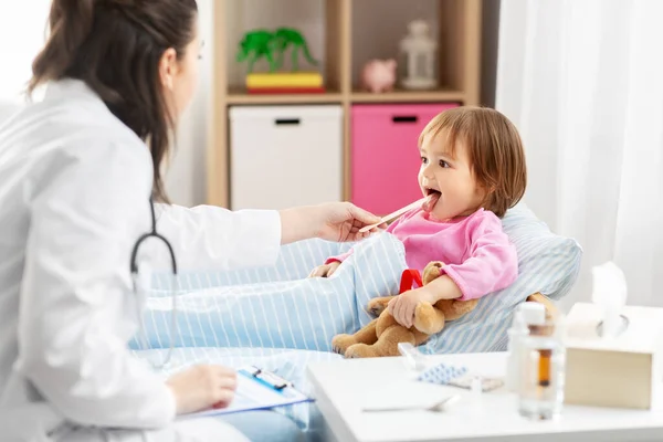 Médico verificando doente meninas garganta em casa — Fotografia de Stock