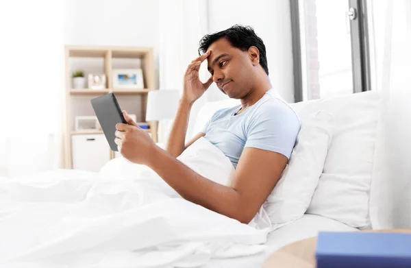 Hombre indio con tableta pc en la cama en casa — Foto de Stock