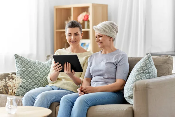 Fille et mère aînée avec tablette pc à la maison — Photo