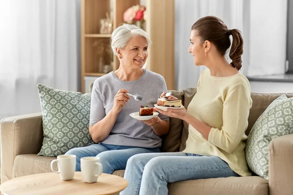 Oude moeder en volwassen dochter eten taart thuis — Stockfoto