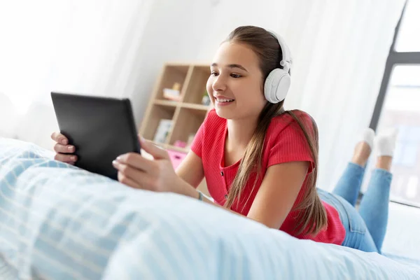 Chica en auriculares escuchando música en la tableta de la PC — Foto de Stock