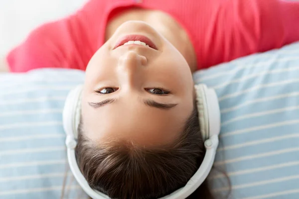 Flicka i hörlurar lyssnar på musik hemma — Stockfoto