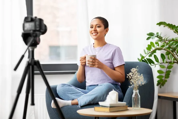 Žena blogger s kamerou a kávou doma — Stock fotografie