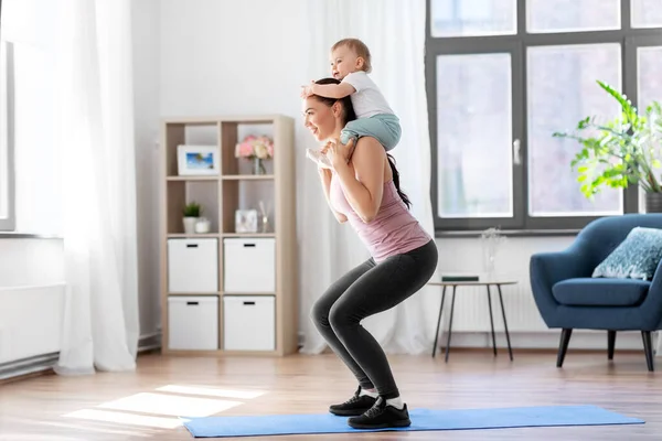 Mãe feliz com pequeno bebê se exercitando em casa — Fotografia de Stock