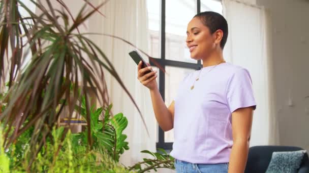 African american woman with smartphone at home — Stock Video