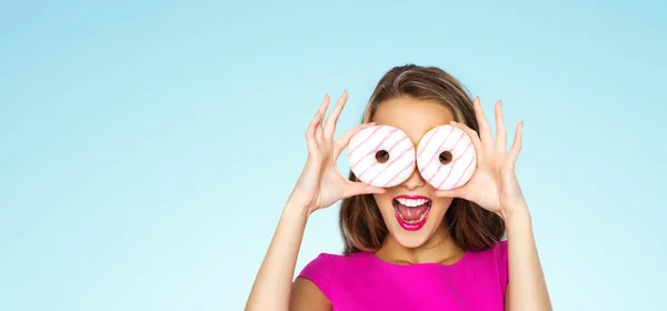 Mulher feliz ou menina adolescente olhando através de donuts — Fotografia de Stock