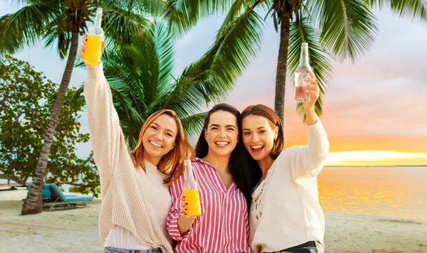 Mulheres jovens brindando bebidas não alcoólicas na praia — Fotografia de Stock