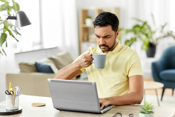 Hombre con portátil beber café en casa oficina — Foto de Stock