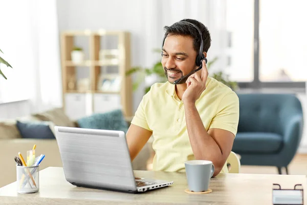 Hombre indio con auriculares y portátil trabajando en casa — Foto de Stock