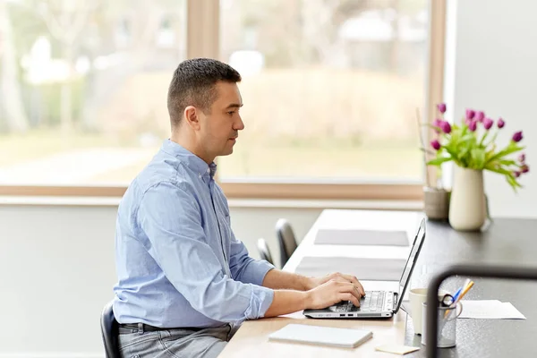 Homme avec ordinateur portable travaillant au bureau à domicile — Photo