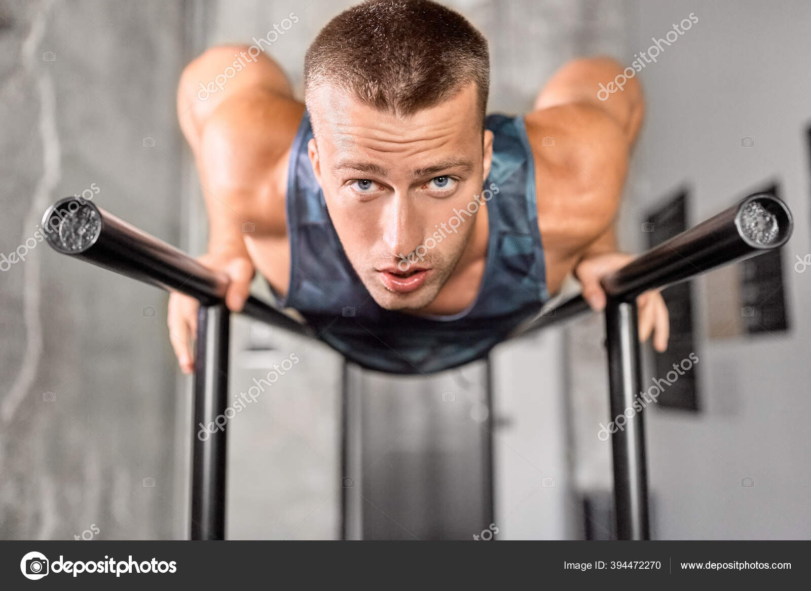 Hombre haciendo flexiones en barras paralelas en el gimnasio