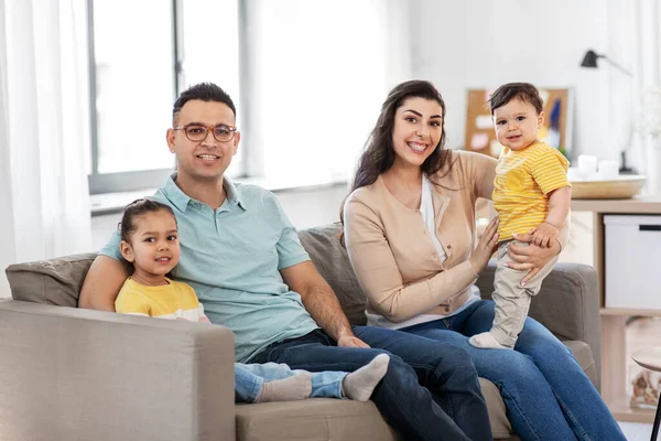 Retrato de la familia feliz sentado en el sofá en casa —  Fotos de Stock