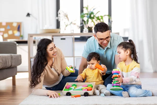 Família feliz pálido com brinquedos de madeira em casa — Fotografia de Stock