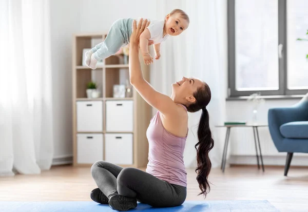 Glückliche Mutter mit kleinem Baby, das zu Hause Sport treibt — Stockfoto