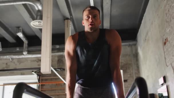 Hombre flexionar abdominales en barras paralelas en el gimnasio — Vídeos de Stock