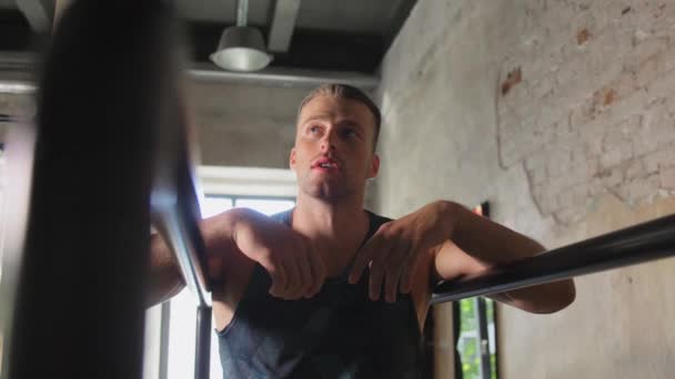 Jeune homme fatigué dans les bars parallèles dans la salle de gym — Video