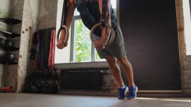 Мужчина отжимается на гимнастических кольцах в спортзале — стоковое видео