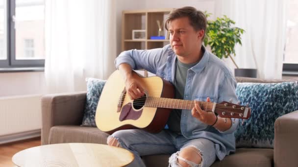 Giovane uomo che suona la chitarra a casa — Video Stock