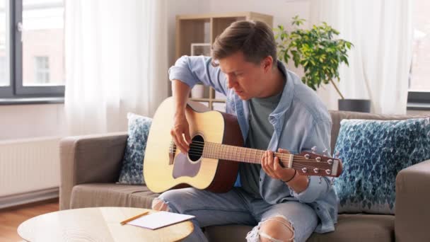 Молодий чоловік грає на гітарі вдома — стокове відео