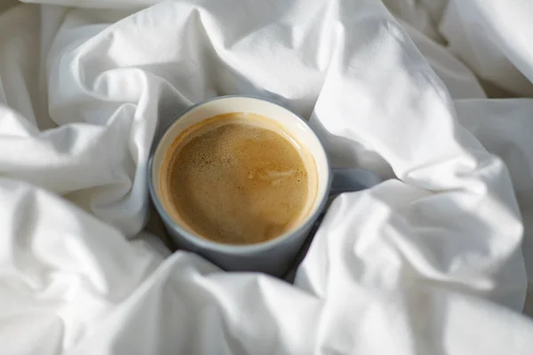 Filiżanka kawy w łóżku — Zdjęcie stockowe