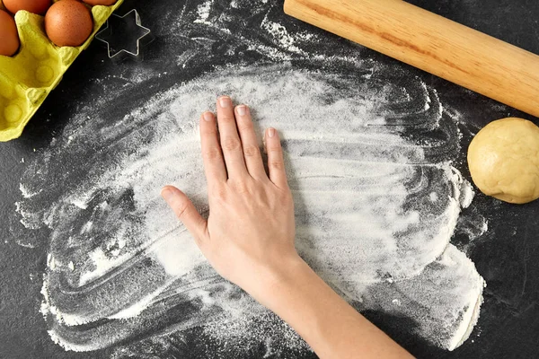 Mão com farinha, massa e rolo de pino na mesa — Fotografia de Stock