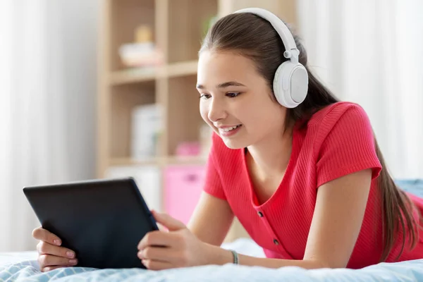 Kulaklıklı kız tablet bilgisayarda müzik dinliyor. — Stok fotoğraf