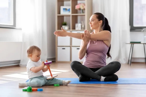 Mãe feliz com pequeno bebê se exercitando em casa — Fotografia de Stock