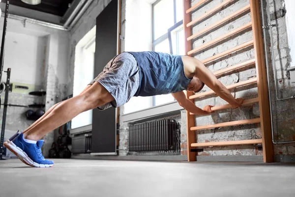 Hombre haciendo ejercicio en gimnasia barras de pared en el gimnasio —  Fotos de Stock