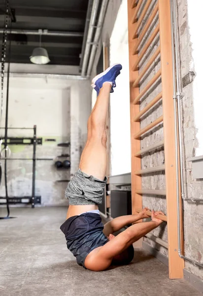 Hombre haciendo ejercicio en gimnasia barras de pared en el gimnasio — Foto de Stock