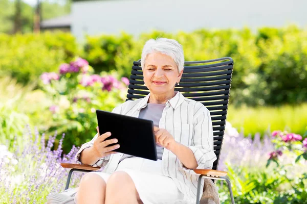 Szczęśliwa seniorka z tabletem w ogrodzie letnim — Zdjęcie stockowe