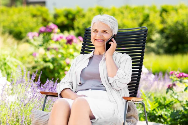 Boldog idős nő hív telefonon a kertben — Stock Fotó