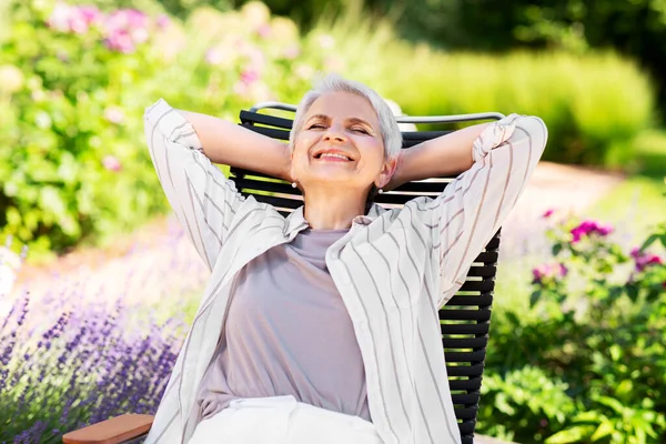 Happy senior woman resting at summer garden — Stock Photo, Image