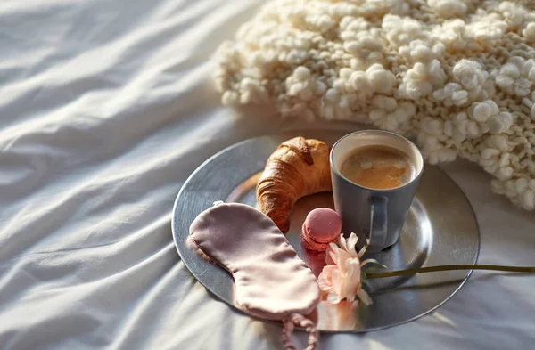 Croissant, café et masque de couchage pour les yeux au lit — Photo