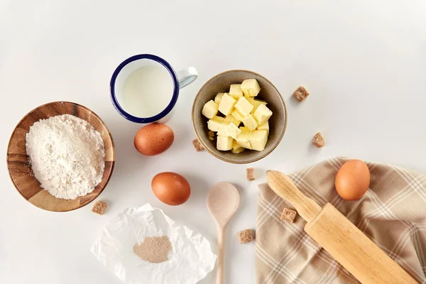 Rolling pin, butter, eggs, flour, milk and sugar — Stock Photo, Image