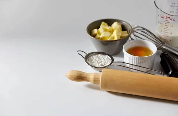 Nudelholz, Butter, Eier, Mehl, Milch und Schneebesen — Stockfoto