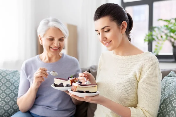 お母さんと大人の娘が家でケーキを食べて — ストック写真