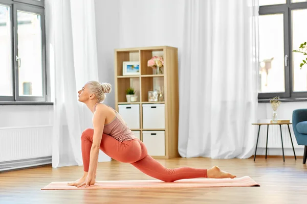 Mujer haciendo yoga y ejercicio de baja embestida en casa — Foto de Stock