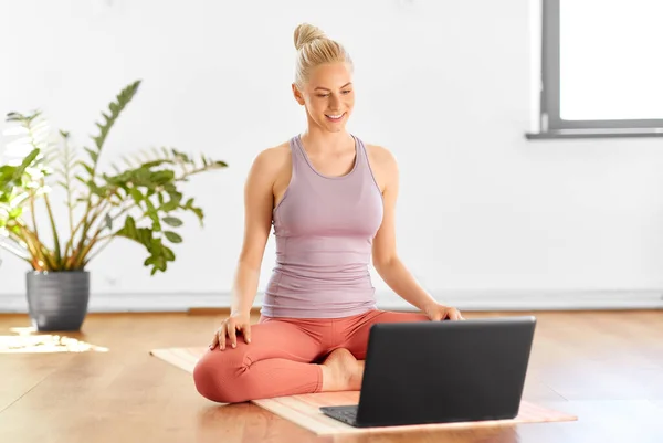 Donna con computer portatile a casa o studio di yoga — Foto Stock