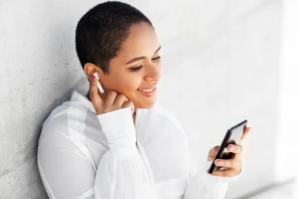 Donna afroamericana con auricolari e telefono — Foto Stock