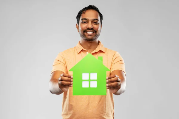 Hombre indio sonriente sosteniendo icono de casa verde —  Fotos de Stock