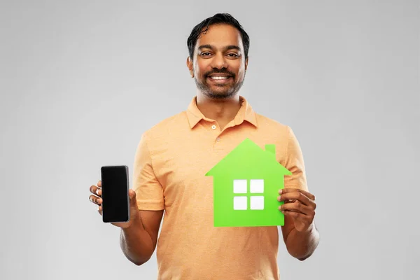 Homem indiano feliz com casa verde e smartphone — Fotografia de Stock