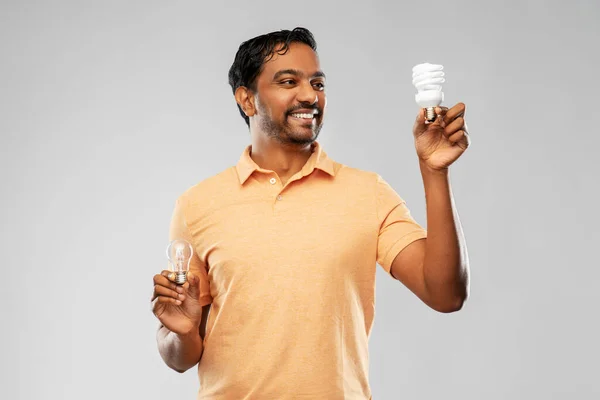 Sorridente indiana homem comparando diferentes lâmpadas — Fotografia de Stock
