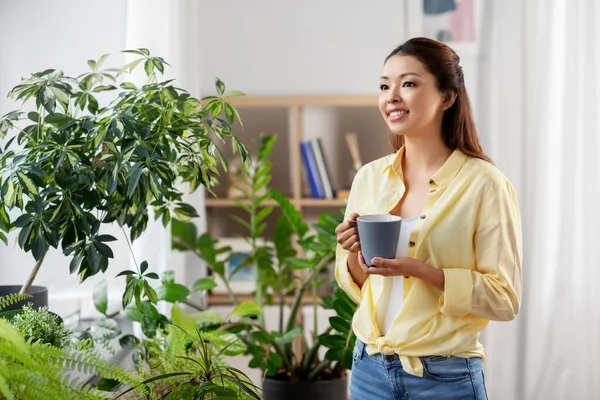 Glad leende asiatisk kvinna dricka kaffe hemma — Stockfoto