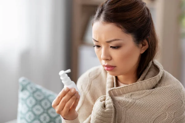 Doente asiático mulher com oral spray medicina em casa — Fotografia de Stock