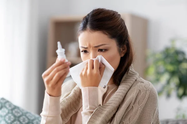 Doente asiático mulher com nasal spray medicina em casa — Fotografia de Stock
